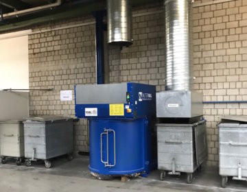 Universalverdichter für Abfall vor Wand